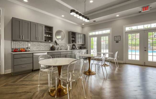 a kitchen with gray cabinets and a white table and chairs