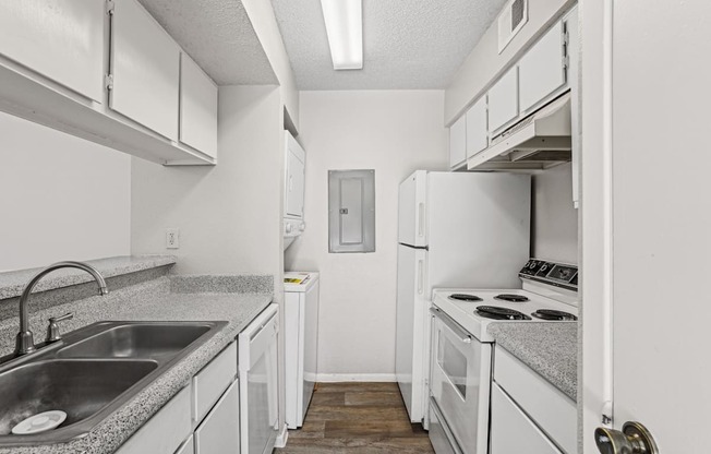 A kitchen with white cabinets and a stove top oven.