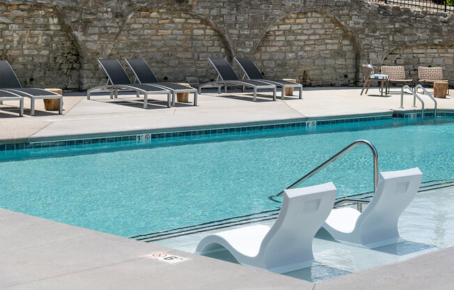 a swimming pool with some chairs next to it at The Heights Apartments, Cincinnati, 45220