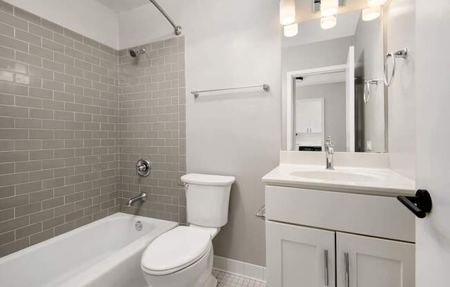A white toilet sits next to a white sink in a bathroom.