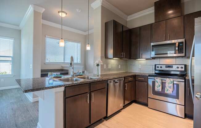 Kitchen with stainless steel appliances, brushed-nickel hardware, and dark cabinets