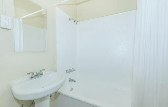 a white sink sitting under a mirror