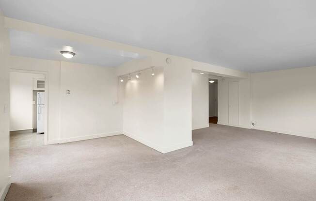 a living room with white walls and a carpet floor