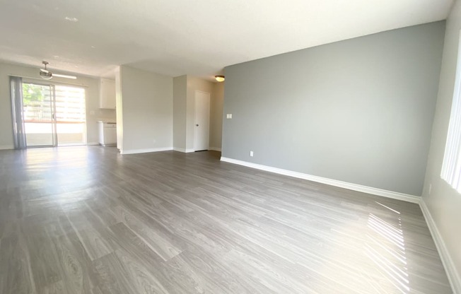 the living room and dining room of an apartment with wood flooring