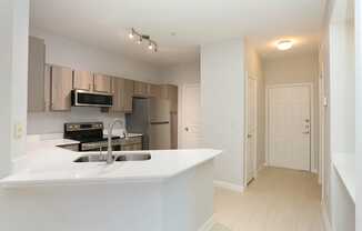 A kitchen with a sink and a refrigerator.