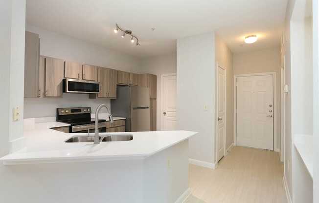 A kitchen with a sink and a refrigerator.