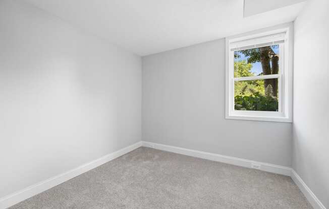 an empty room with white walls and a window