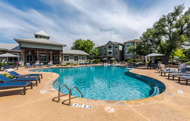 A large swimming pool with a building in the background.