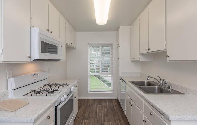 a kitchen with a stove a sink and a microwave