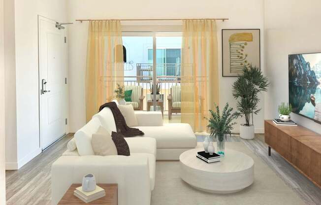 A living room with a white sofa, a round coffee table, and a flat-screen TV.