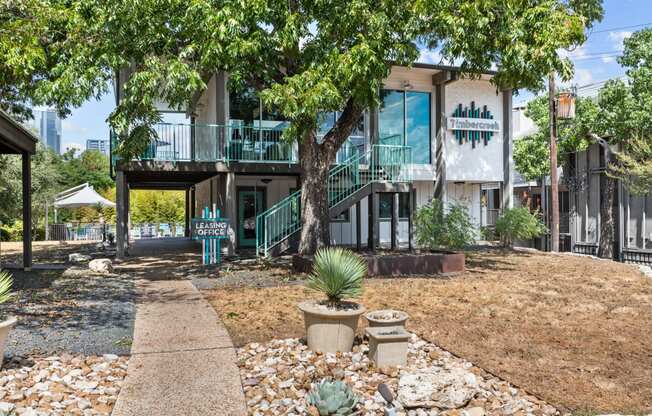 a house with a sidewalk and trees in front of it