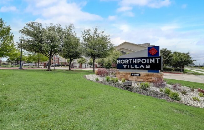 a sign for northpoint village with trees in the background