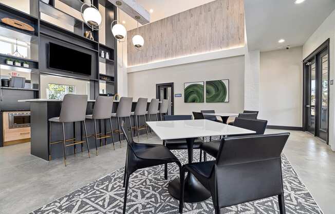 a dining area with tables and chairs and a kitchen