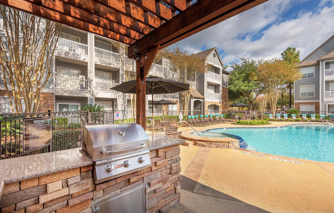 Lodge at Cypresswood Apartments - Poolside BBQ grills