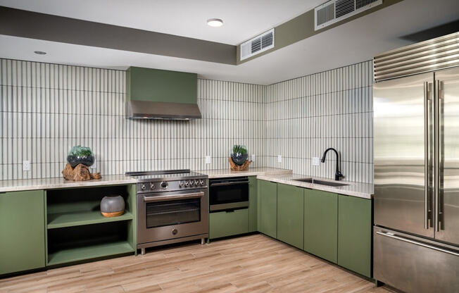 a kitchen with green cabinets and stainless steel appliances