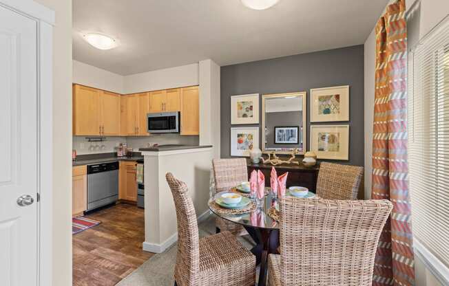 a dining room table with chairs and a kitchen in the background