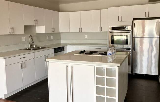 A kitchen with white cabinets and a wooden floor.