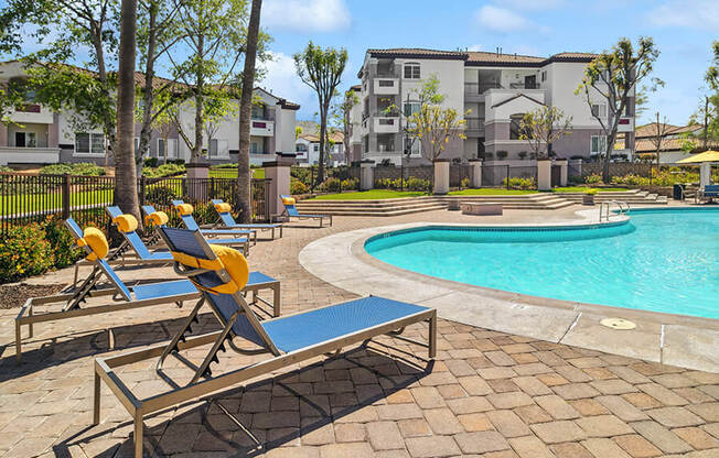 Community Swimming Pool with Pool Furniture at Reserve at Rancho Apartments located in Moreno Valley, CA.
