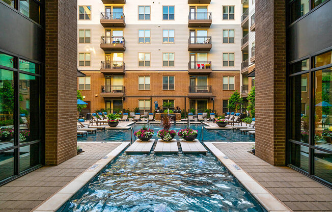 A long rectangular pool with a fountain in the middle.
