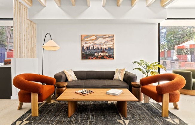 A living room with a grey couch, orange chairs, and a wooden coffee table.