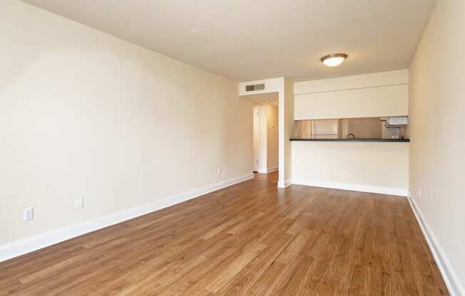 A room with wooden flooring and white walls.