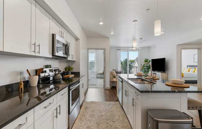 an open kitchen with white cabinets and a large counter top