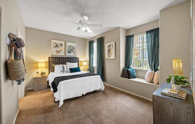A bedroom with a large bed and a ceiling fan.
