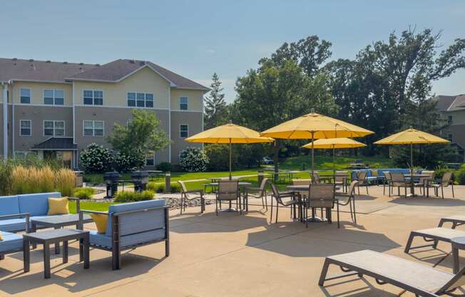 an outdoor patio with tables and chairs and umbrellas