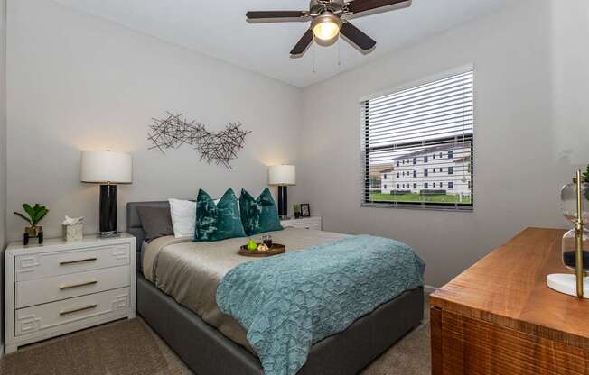 A bedroom with a bed, nightstand, and window.