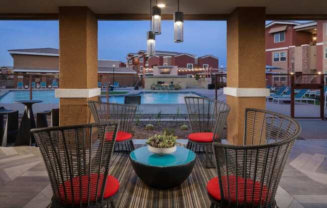 a patio with a table and chairs and a pool in the background at Zaterra Luxury Apartments, Chandler, AZ, 85286