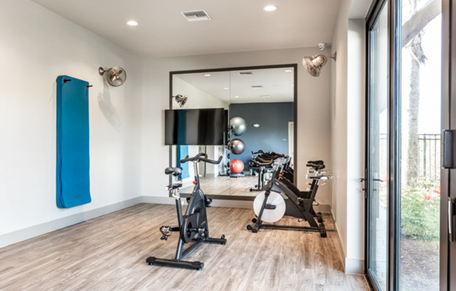 furnished yoga and pilates room with equipment and mirror