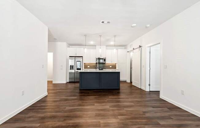 a kitchen with white walls and a black island in the middle of it