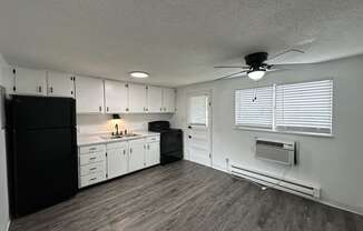 a kitchen with white cabinets and black appliances