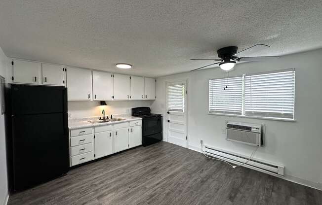 a kitchen with white cabinets and black appliances