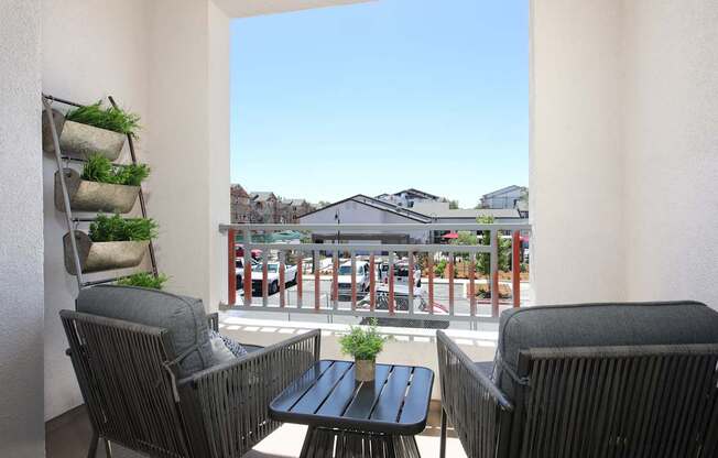 A patio with a table and chairs overlooking a street.