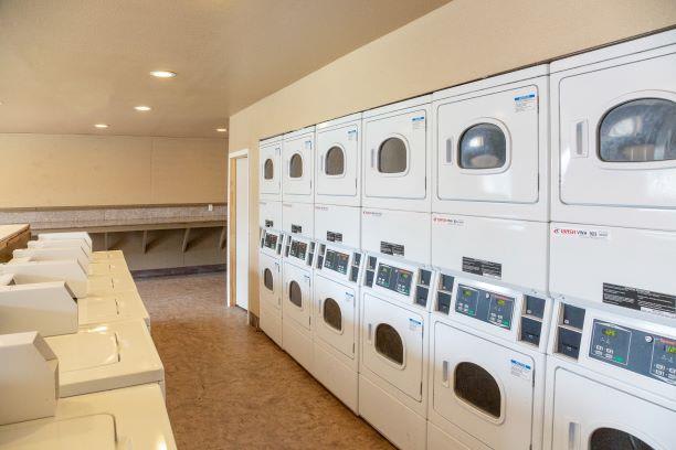 Laundry Center with Machines Next to Folding Counter at Aspen Park Apartments, Sacramento