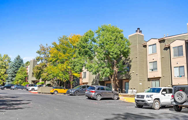 A parking lot with cars and apartment buildings in the background.