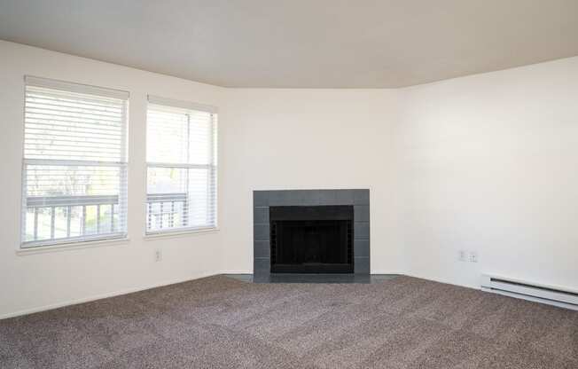 a living room with a fireplace and two windows