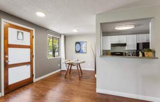 A kitchen area with a dining table and chairs.