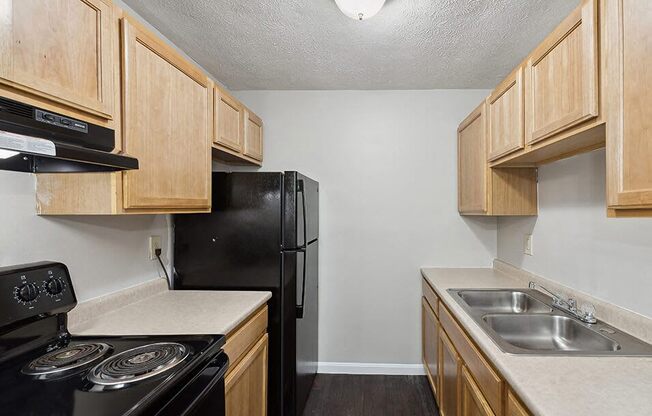 a kitchen with a stove refrigerator and sink