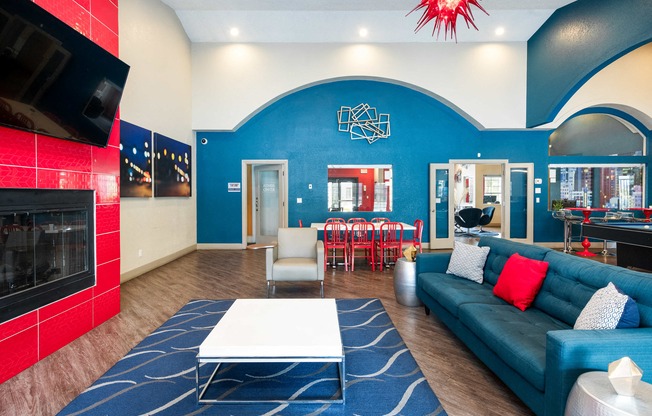 a living room with a blue couch and a table and a fireplace