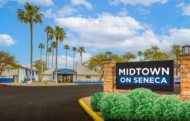 The image shows a sign that reads "Midtown on Seneca" in front of a building with palm trees in the background.