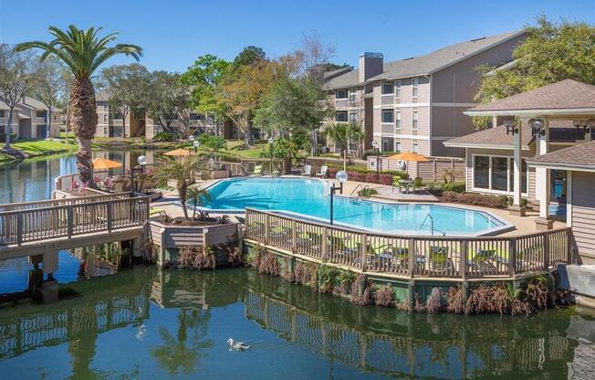 a swimming pool with a wooden deck next to a body of water