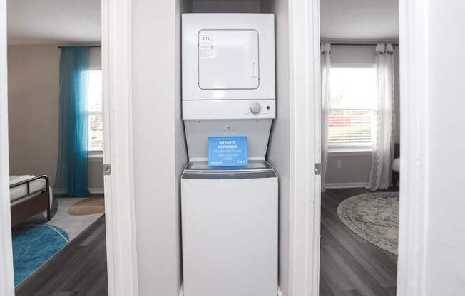 A small white box with a blue label is on top of a white refrigerator.