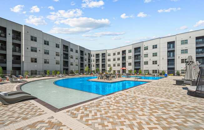 a large swimming pool in front of an apartment building