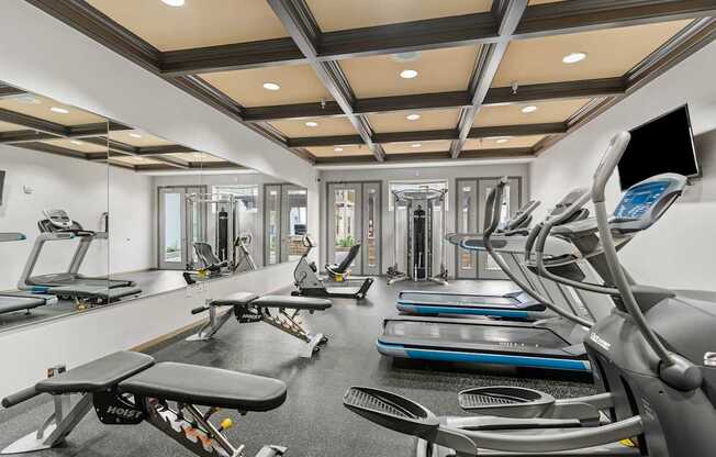 A gym with treadmills, exercise bikes, and other equipment.