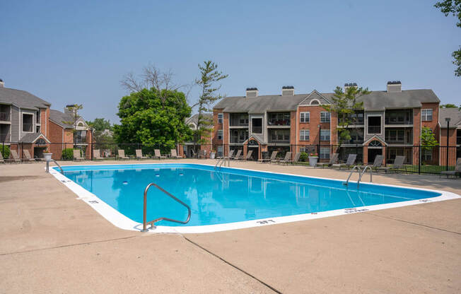 a swimming pool with an apartment building in the background