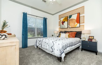 a bedroom with a bed and a window with blue curtains