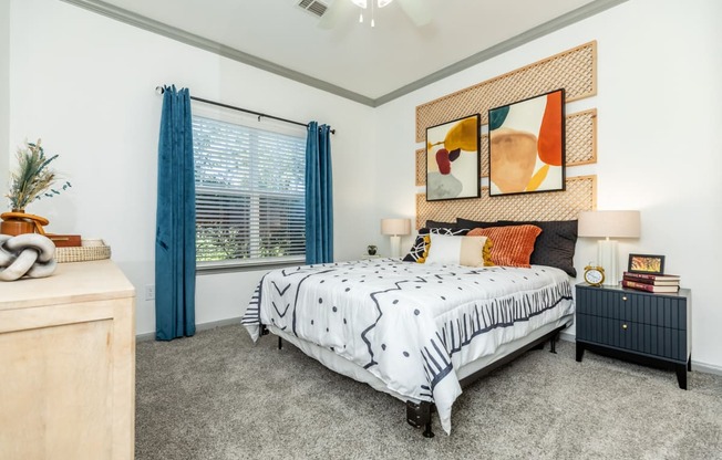 a bedroom with a bed and a window with blue curtains