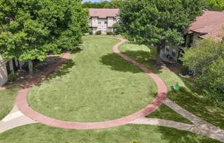 an aerial view of a grassy area with a circular walkway